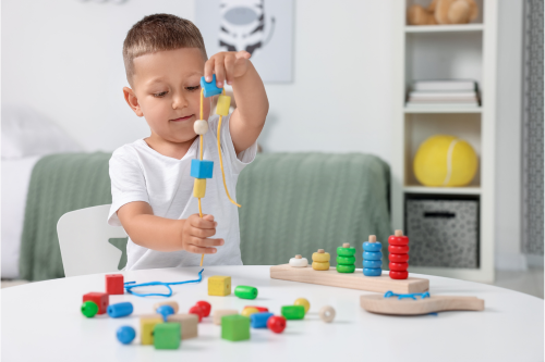 Motor Skills Development. Little Boy Playing with Wooden Pieces